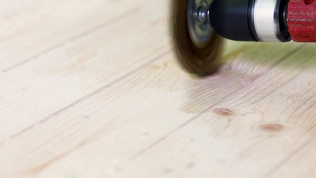 Wire brush for wood working, on a drill. Female hand is holding brushing machine