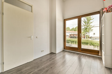 Obraz premium an empty room with wood flooring and sliding glass door that leads to the outside patio, which has been painted white
