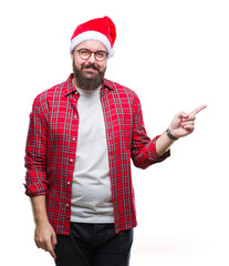 Young caucasian man wearing christmas hat over isolated background with a big smile on face, pointing with hand and finger to the side looking at the camera.