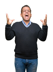 Middle age bussines arab man wearing glasses over isolated background crazy and mad shouting and yelling with aggressive expression and arms raised. Frustration concept.