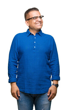 Middle age arab man wearing glasses over isolated background smiling looking side and staring away thinking.