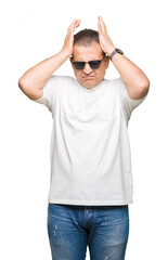 Fototapeta premium Middle age arab man wearig white t-shirt and sunglasses over isolated background suffering from headache desperate and stressed because pain and migraine. Hands on head.
