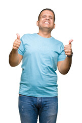 Middle age arab man wearing blue t-shirt over isolated background success sign doing positive gesture with hand, thumbs up smiling and happy. Looking at the camera