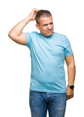Fototapeta premium Middle age arab man wearing blue t-shirt over isolated background confuse and wonder about question. Uncertain with doubt, thinking with hand on head. Pensive concept.