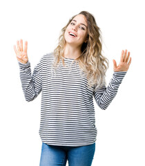 Beautiful young blonde woman wearing stripes sweater over isolated background showing and pointing...