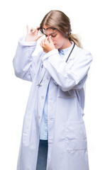 Beautiful young blonde doctor woman wearing medical uniform over isolated background tired rubbing nose and eyes feeling fatigue and headache. Stress and frustration concept.