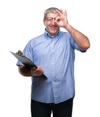 Handsome senior inspector man holding clipboard over isolated background with happy face smiling...