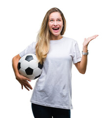 Young beautiful blonde woman holding soccer ball over isolated background very happy and excited, winner expression celebrating victory screaming with big smile and raised hands