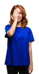 Young beautiful woman over isolated background covering one eye with hand with confident smile on face and surprise emotion.