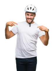 Young handsome man wearing cyclist safety helmet over isolated background looking confident with smile on face, pointing oneself with fingers proud and happy.