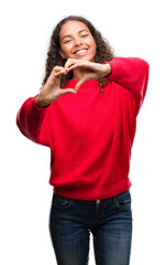 Young hispanic woman wearing red sweater smiling in love showing heart symbol and shape with hands. Romantic concept.