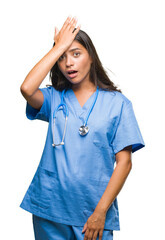 Young arab doctor surgeon woman over isolated background surprised with hand on head for mistake,...