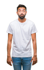 Fototapeta premium Adult hispanic man over isolated background puffing cheeks with funny face. Mouth inflated with air, crazy expression.