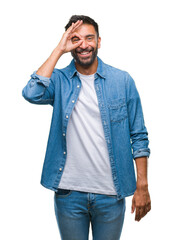 Adult hispanic man over isolated background doing ok gesture with hand smiling, eye looking through fingers with happy face.