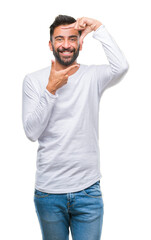 Adult hispanic man over isolated background smiling making frame with hands and fingers with happy face. Creativity and photography concept.