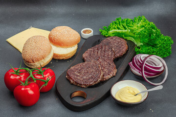 Grilled burger patties. Hot beef cutlets, buns, vegetables and sauce. Homemade American classic