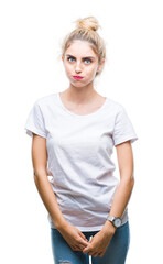 Fototapeta premium Young beautiful blonde woman wearing white t-shirt over isolated background making fish face with lips, crazy and comical gesture. Funny expression.