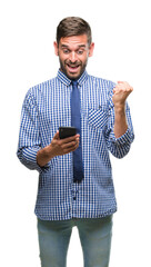 Young hadsome man texting sending message using smartphone over isolated background screaming proud and celebrating victory and success very excited, cheering emotion