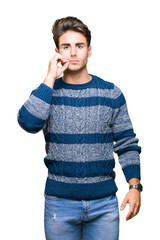 Young handsome man over isolated background mouth and lips shut as zip with fingers. Secret and...