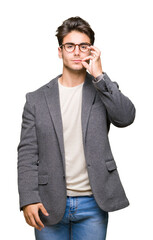 Fototapeta premium Young business man wearing glasses over isolated background mouth and lips shut as zip with fingers. Secret and silent, taboo talking