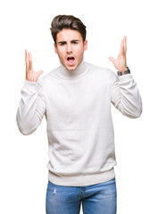 Naklejka premium Young handsome man wearing turtleneck sweater over isolated background celebrating mad and crazy for success with arms raised and closed eyes screaming excited. Winner concept