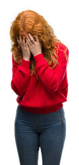 Young redhead woman wearing red sweater with sad expression covering face with hands while crying. Depression concept.