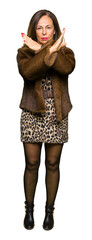 Beautiful middle age elegant woman wearing mink coat Rejection expression crossing arms doing negative sign, angry face