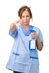 Middle age brunette cleaner woman wearing housework uniform over isolated background with angry face, negative sign showing dislike with thumbs down, rejection concept