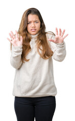 Fototapeta na wymiar Young beautiful brunette woman wearing turtleneck sweater over isolated background afraid and terrified with fear expression stop gesture with hands, shouting in shock. Panic concept.