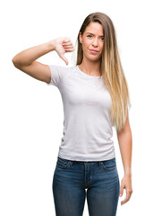 Beautiful young woman wearing t-shirt and jeans with angry face, negative sign showing dislike with thumbs down, rejection concept