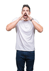 Young man wearing casual white t-shirt over isolated background Shouting angry out loud with hands over mouth
