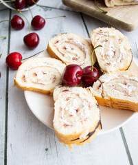 Cherry strudel, on a wooden board, with fresh cherries. On a wooden background
