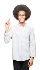 Young african american man with afro hair wearing glasses showing and pointing up with finger number one while smiling confident and happy.