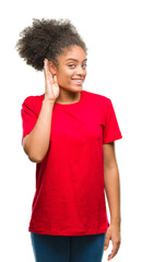 Young afro american woman over isolated background smiling with hand over ear listening an hearing to rumor or gossip. Deafness concept.