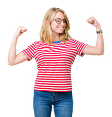 Obraz premium Beautiful young woman wearing glasses over isolated background showing arms muscles smiling proud. Fitness concept.