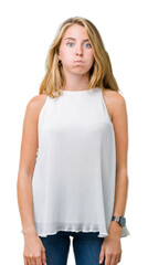 Fototapeta premium Beautiful young elegant woman over isolated background puffing cheeks with funny face. Mouth inflated with air, crazy expression.