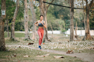 Naklejka premium Young sporty woman running in green park.Sport lifestyle. Motion blur. in sun light
