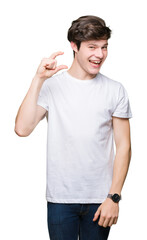 Fototapeta premium Young handsome man wearing casual white t-shirt over isolated background smiling and confident gesturing with hand doing size sign with fingers while looking and the camera. Measure concept.