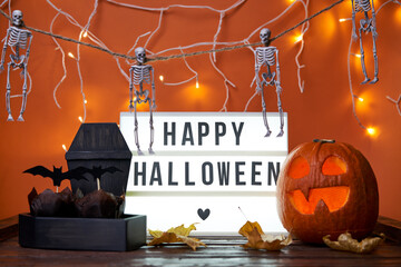 Happy Halloween white sign with black letters, pumpkin and halloween decoration.