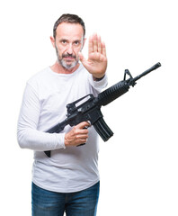 Middle age senior hoary criminal man holding gun weapon over isolated background with open hand doing stop sign with serious and confident expression, defense gesture