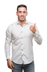 Handsome young business man happy with big smile doing ok sign, thumb up with fingers, excellent sign