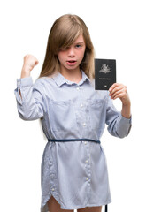 Fototapeta premium Young blonde toddler holding australian passport annoyed and frustrated shouting with anger, crazy and yelling with raised hand, anger concept