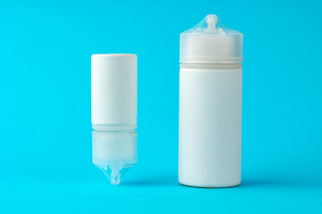 Electronic cigarettes liquid bottles on blue background
