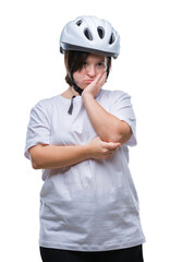 Young adult cyclist woman with down syndrome wearing safety helmet over isolated background thinking looking tired and bored with depression problems with crossed arms.