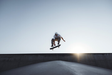 Skater doing kickflip on the ramp at skate park - Stylish skaterboy training outside - Extreme...