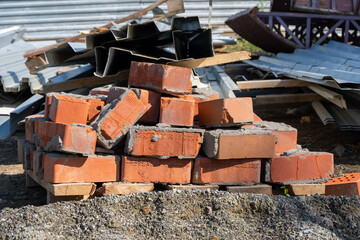 A pile of old red bricks with the remains of dried mortar. Building material red brick with holes. Solid clay bricks used for construction. Concept of repair and building materials
