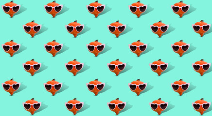 Creative Halloween mosaic made of pumpkin with pink heart shaped sunglasses against pastel mint green background. Minimal concept. Copy space. Autumn art. Pastel fall.