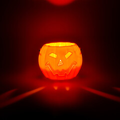 Creative Halloween design made of glowing pumpkin and red lights against black background. Minimal concept. Copy space. Autumn art. Trick or treat.