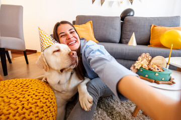 Woman and dog taking selfie at birthday party