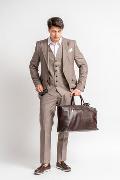A man in a business three-piece suit with a large travel bag for business trips.